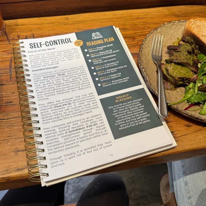The Simple Bible Study open to the Self-Control week beside lunch on a cafe table